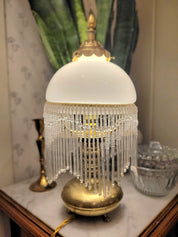 Superbe lampe, pied en laiton reposant sur 3 petits pieds en forme de pattes, abat-jour en opaline blanche et pampilles transparentes