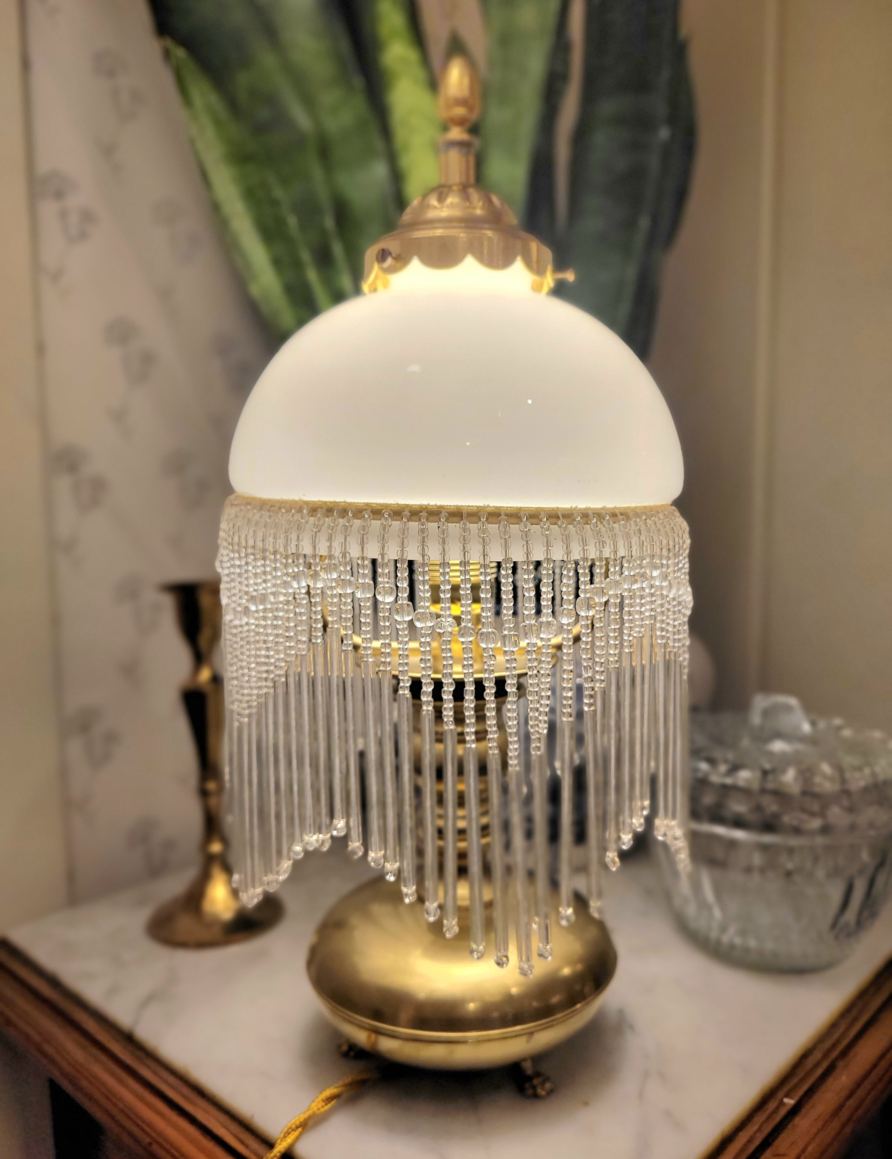 Superbe lampe, pied en laiton reposant sur 3 petits pieds en forme de pattes, abat-jour en opaline blanche et pampilles transparentes