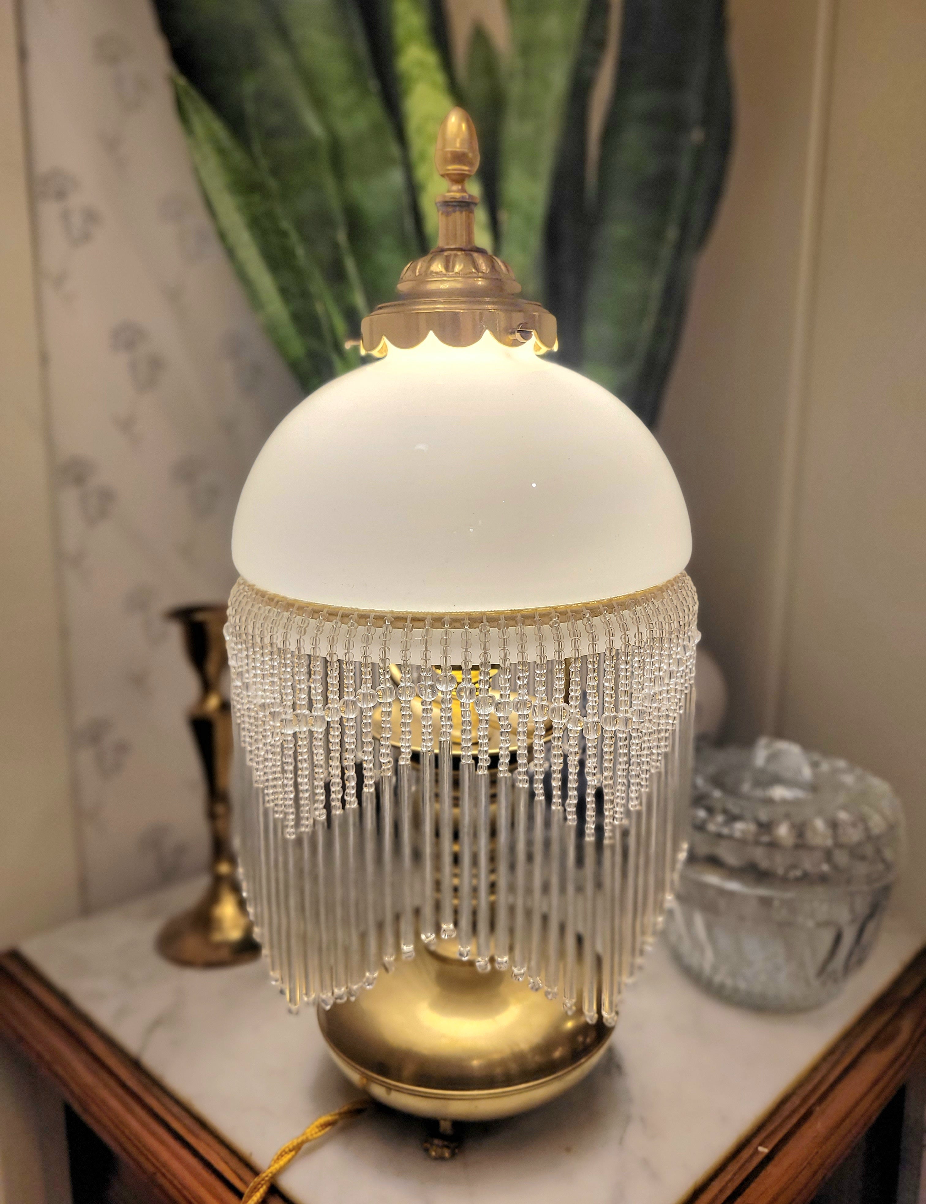 Superbe lampe, pied en laiton reposant sur 3 petits pieds en forme de pattes, abat-jour en opaline blanche et pampilles transparentes