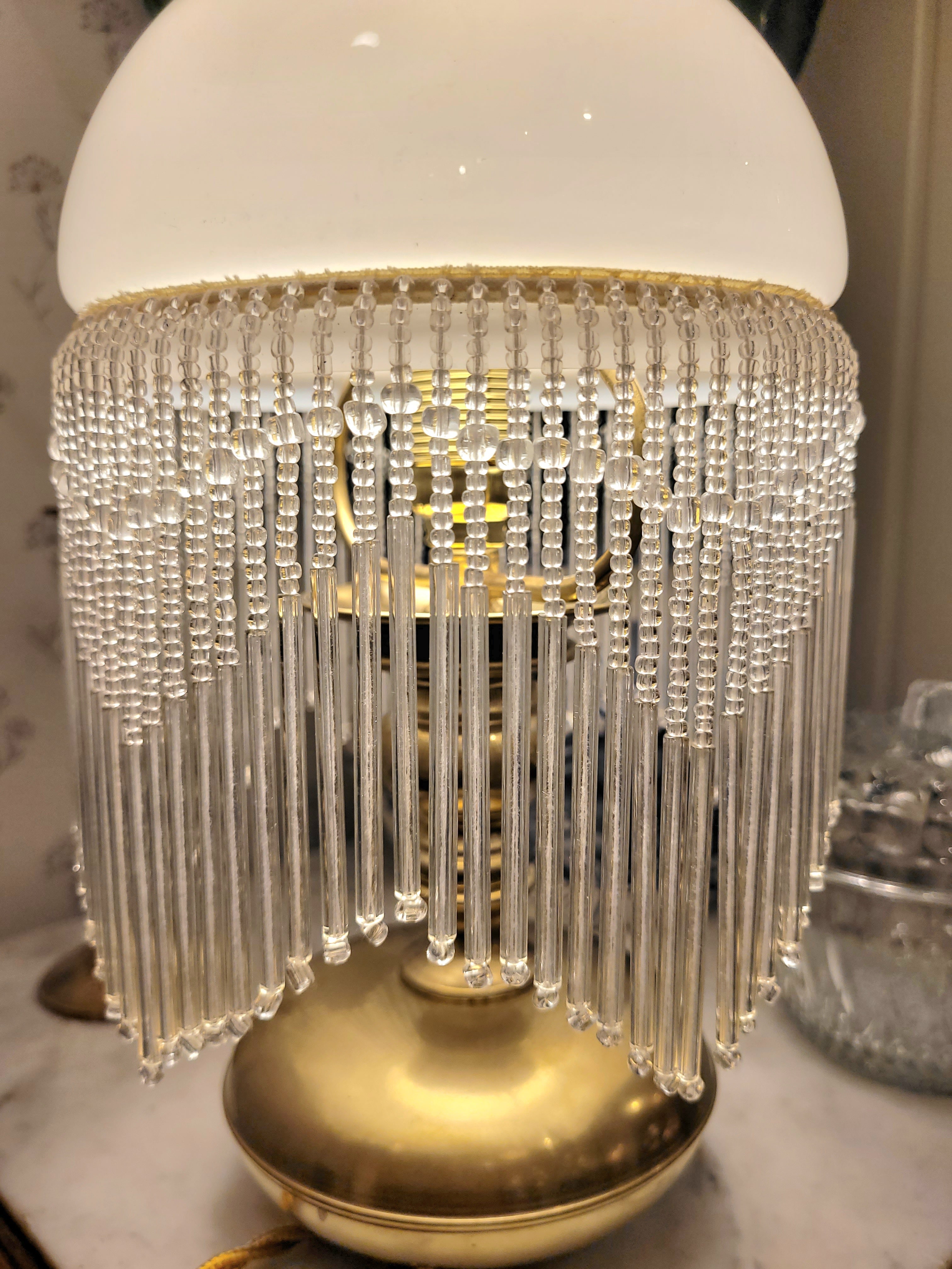 Superbe lampe, pied en laiton reposant sur 3 petits pieds en forme de pattes, abat-jour en opaline blanche et pampilles transparentes